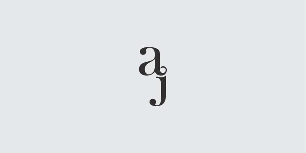 Lowercase letter a and j. The a's typographic tail joins at the tittle of the letter j. Greyscale image.